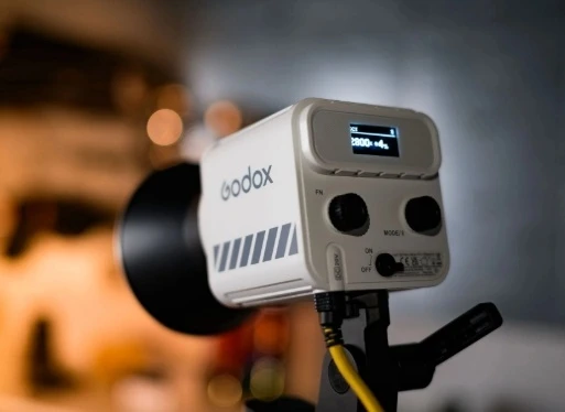 Задня панель моноблока Godox ML60II Bi з увімкненим екраном CCT 2800K, регуляторами та підключеним кабелем живлення на студійній стійці