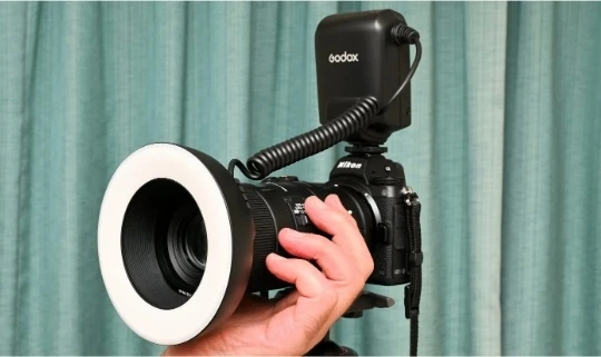 Кільцевий макроспалах Godox ML-150 II з круговим розсіювачем на об'єктиві камери Nikon з підключенням до блоку керування