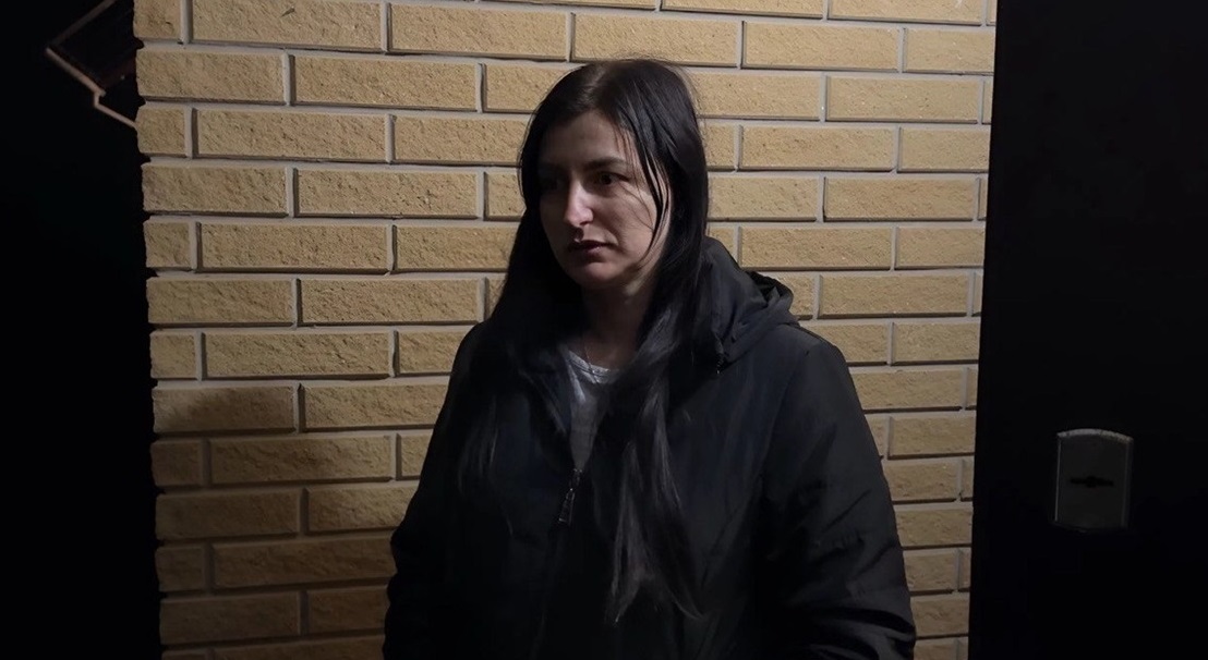 Людмила на фоні будинку
